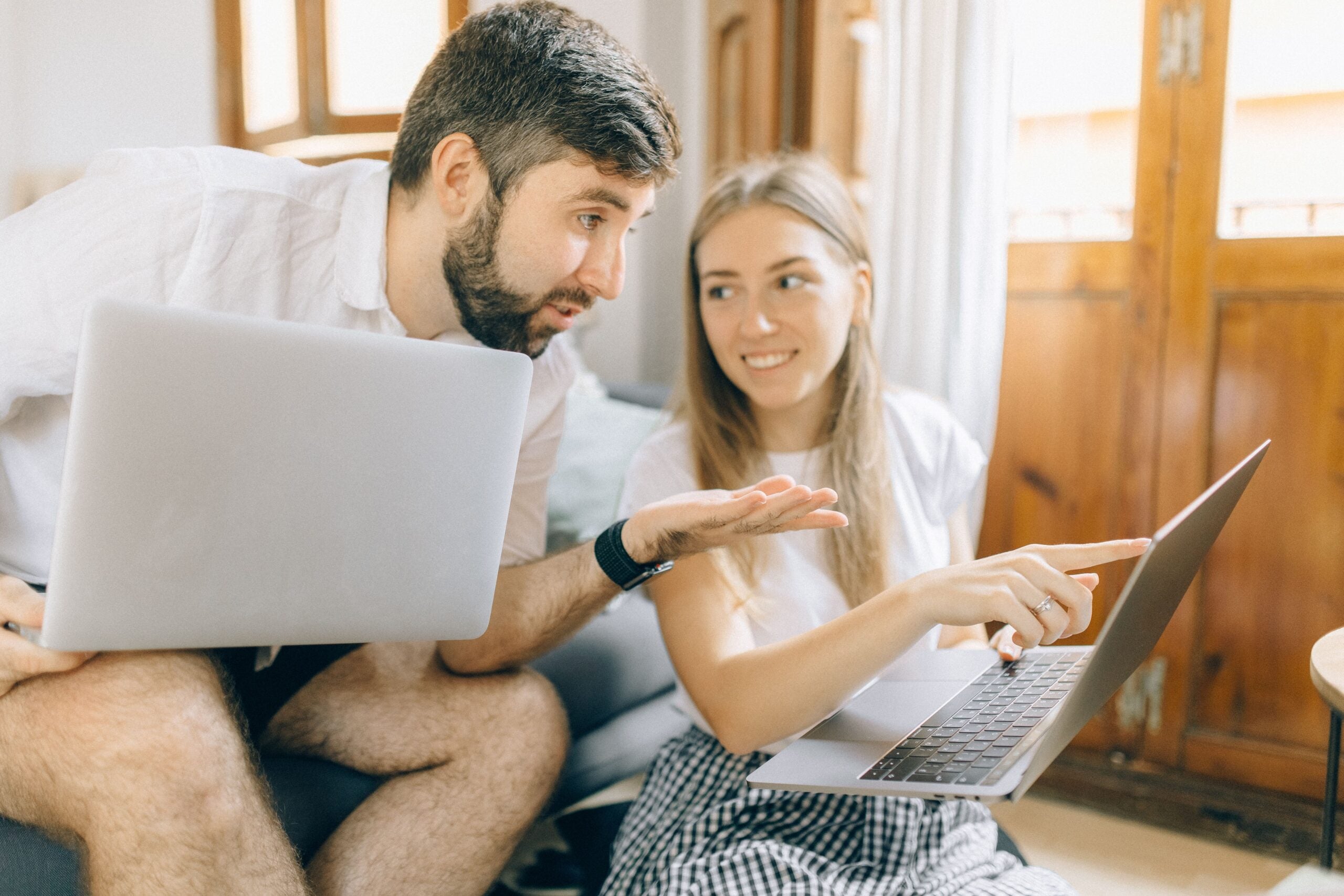 Couple looking at two laptops