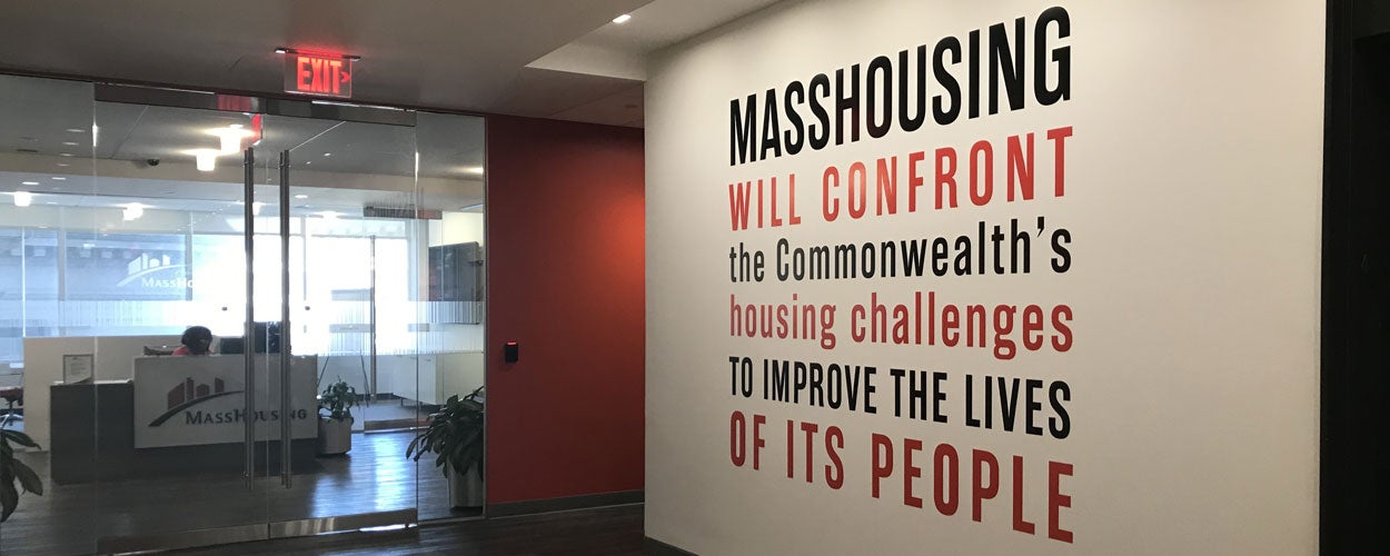 A photo of MassHousing's office lobby showing the Agency's mission statement